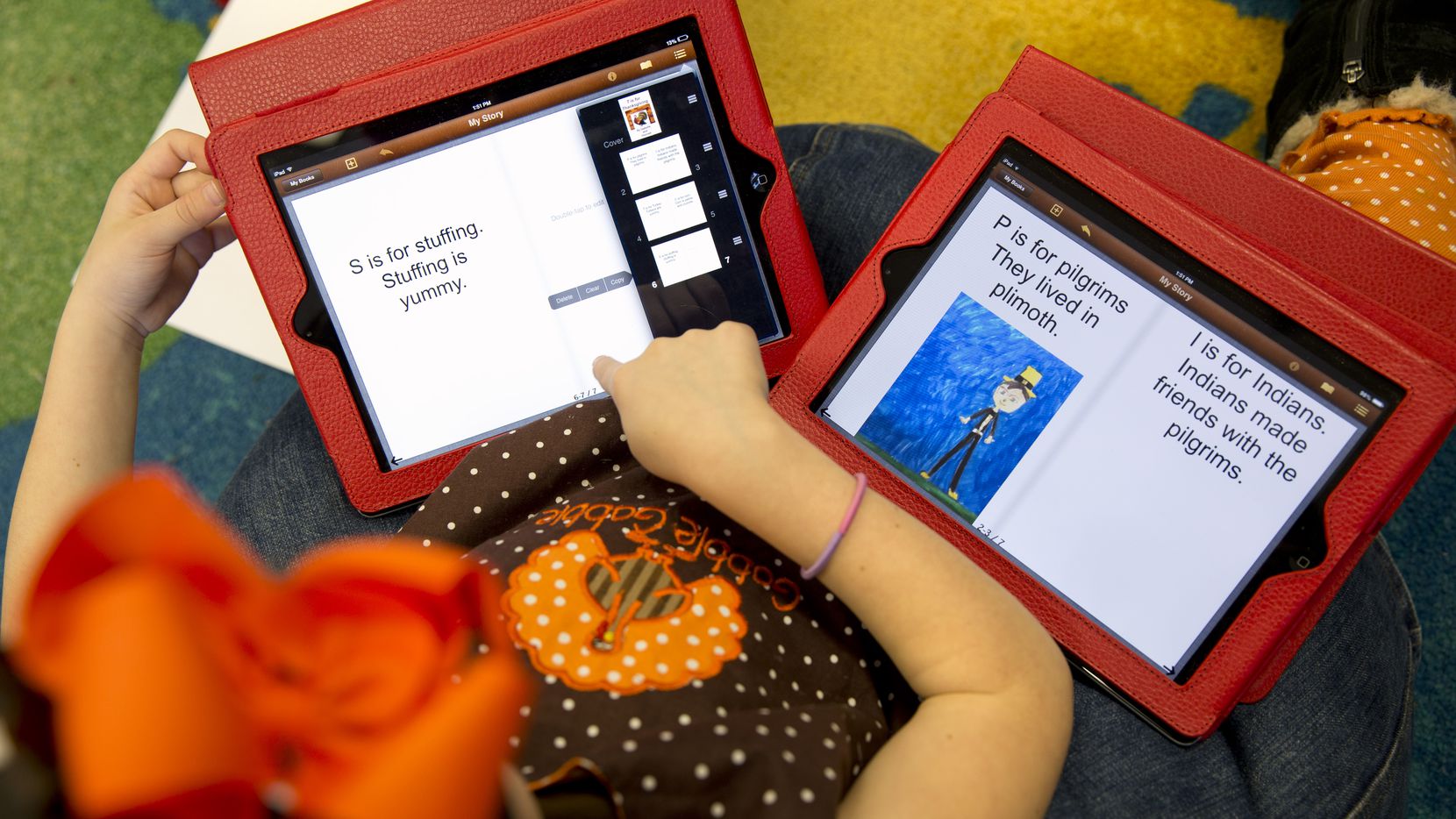 This photo taken Nov. 25, 2013 shows Isabelle Fontana, 7, working on two iPads for an e-book...