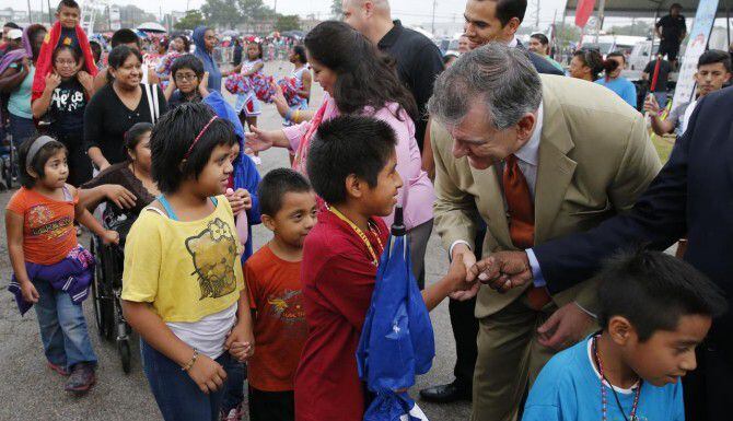 El alcalde de Dallas Mike Rawlings (der.) saluda a niños durante la Feria de Regreso a...