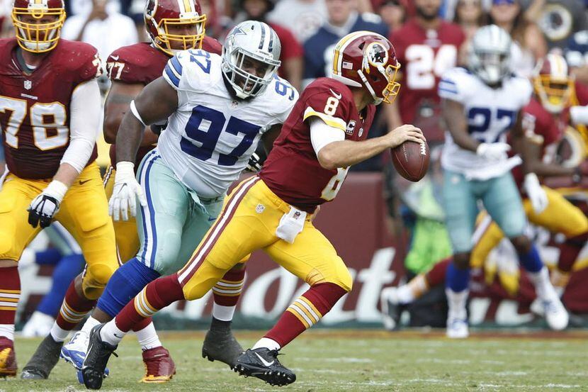 El tacle de Dallas Terrell McClain (97) presiona al mariscal de Washington Kirk Cousins (8)...