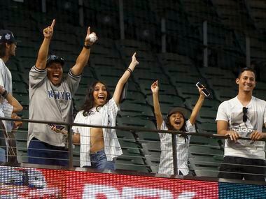 Fans celebrate after catching a ball thrown from New York Yankees right fielder Aaron Judge...