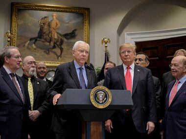 Sen. Orrin Hatch (R-Utah) speaks as President Donald Trump looks on during the signing of...