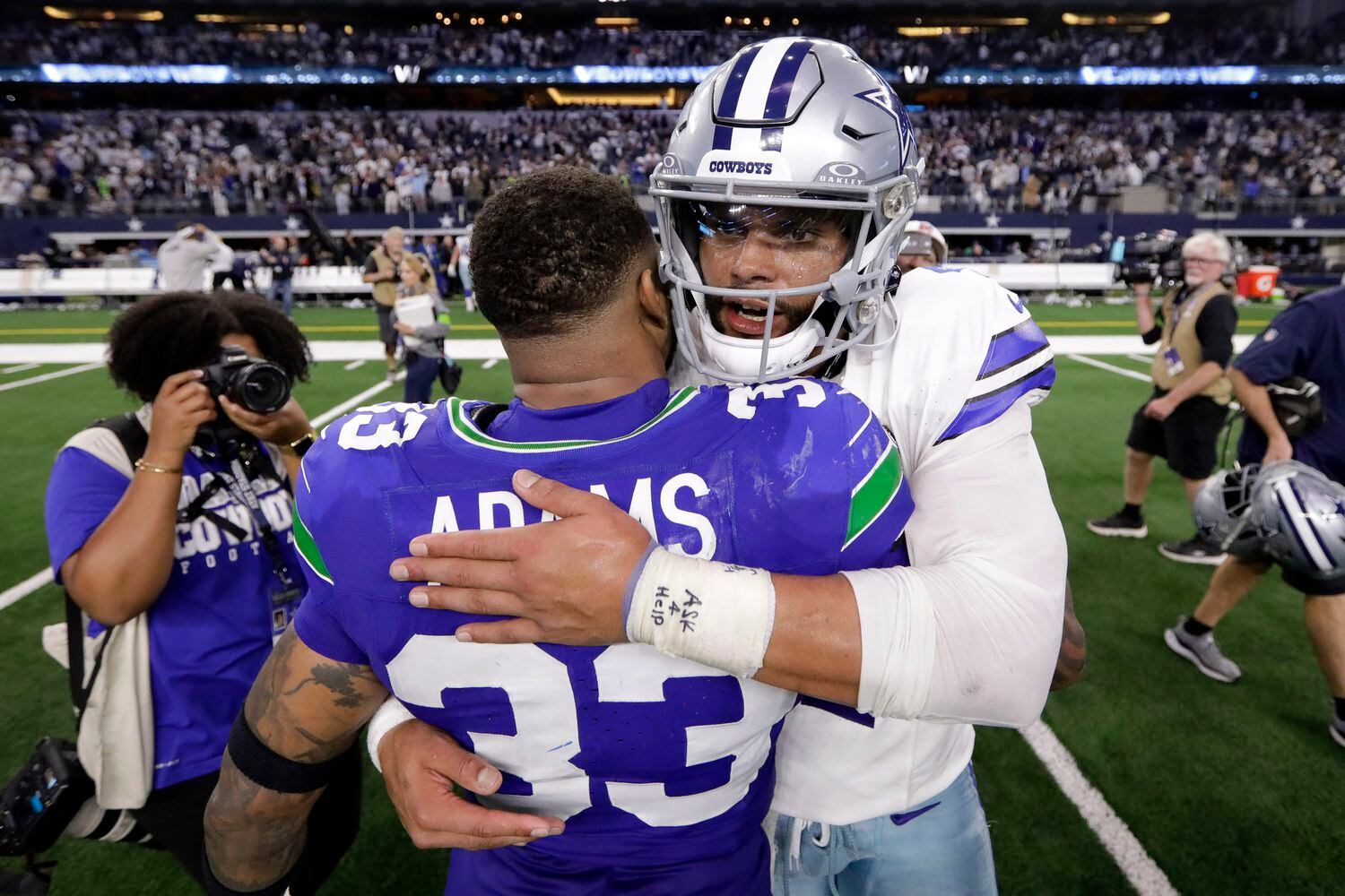 Dallas Cowboys quarterback Dak Prescott (4) receives a hug from Seattle Seahawks safety...