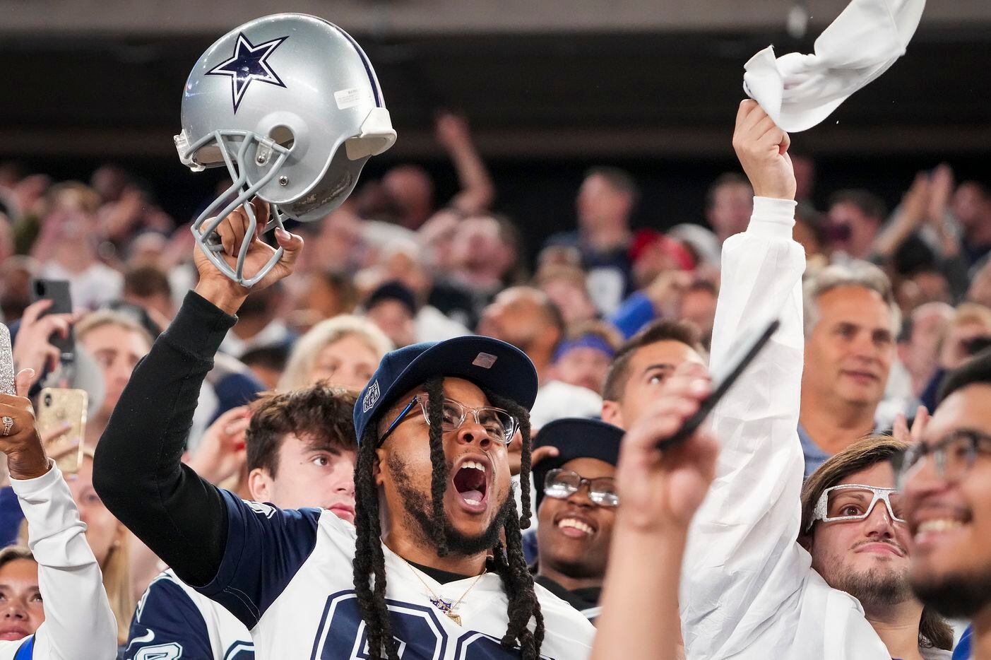 Dallas Cowboys fans cheer their team during the first quarter of an NFL football game...