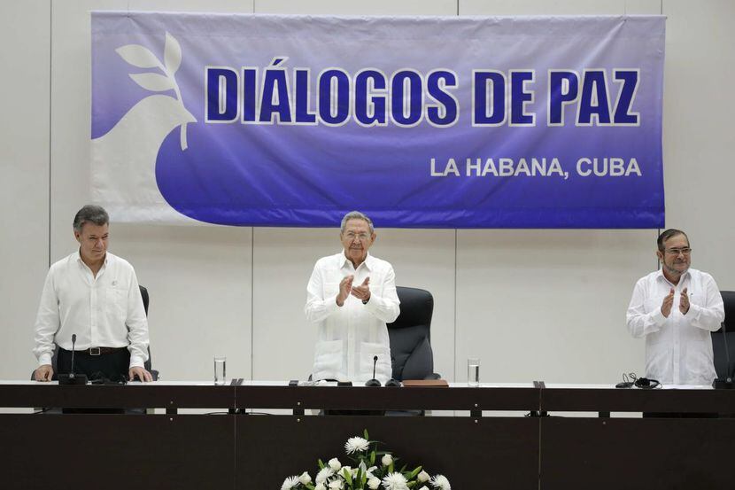 El presidente colombiano Juan Manuel Santos (izq.), el presidente cubano Raúl Castro, y el...