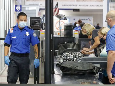 A Transportation Security Administration agent observed travelers stowing their belongings in containers at a security checkpoint at DFW International Airport on September 2nd.
