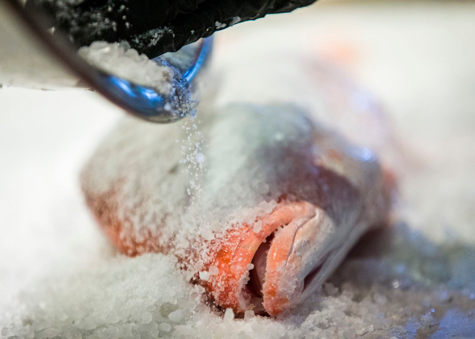 Chef and co-owner Ryan Oruch prepares a Salt-Crusted Red Snapper dish at Sea Breeze Fish...