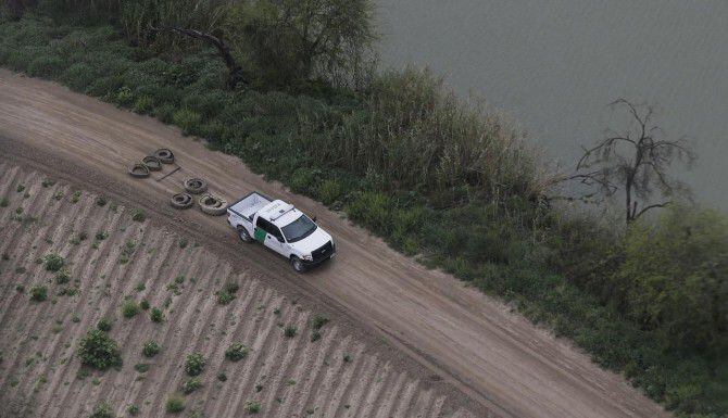 Agentes de la Patrulla Fronteriza aplanan un camino de tierra a lo largo del Río Grande,...