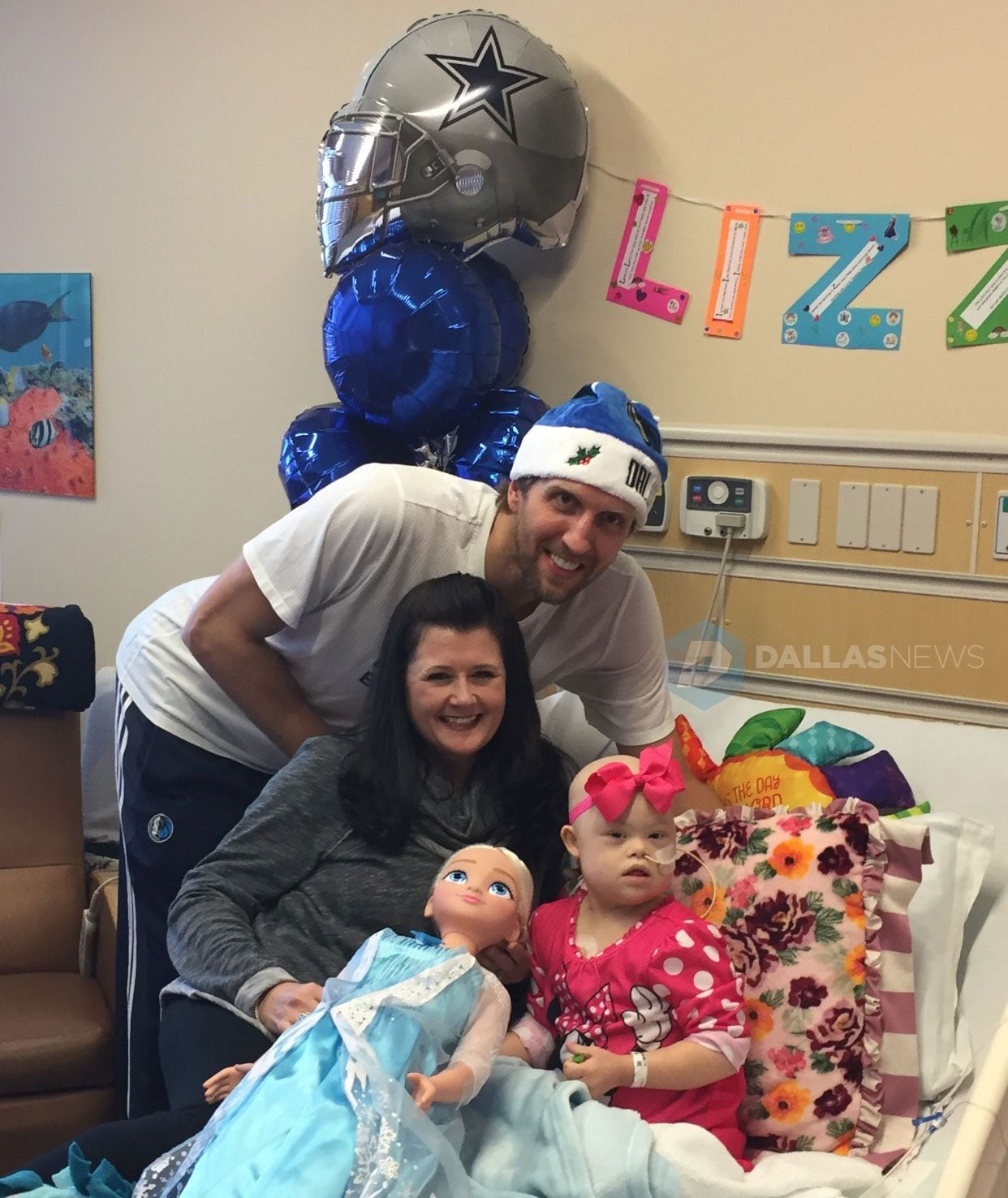 Dirk Nowitzki poses with patient Lizzy Hock, 4, and her mother Angela Hock, at Children's...