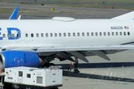 A Medford Jet Center worker walks under a United Boeing 737-824 that landed at Rogue Valley...