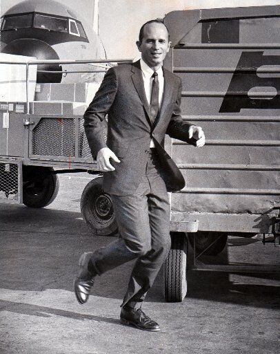 Dr. Kenneth Cooper demonstrates jogging while dressed in a suit during a shoot with...