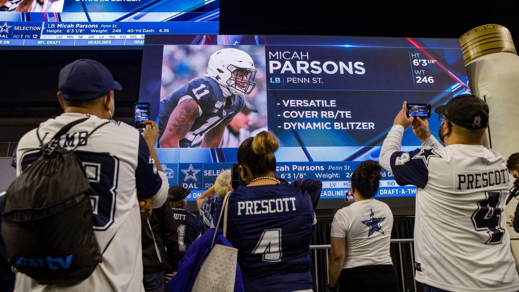 Dallas Cowboys fans take photos of the screen after the team picked Micah Parsons as the No....