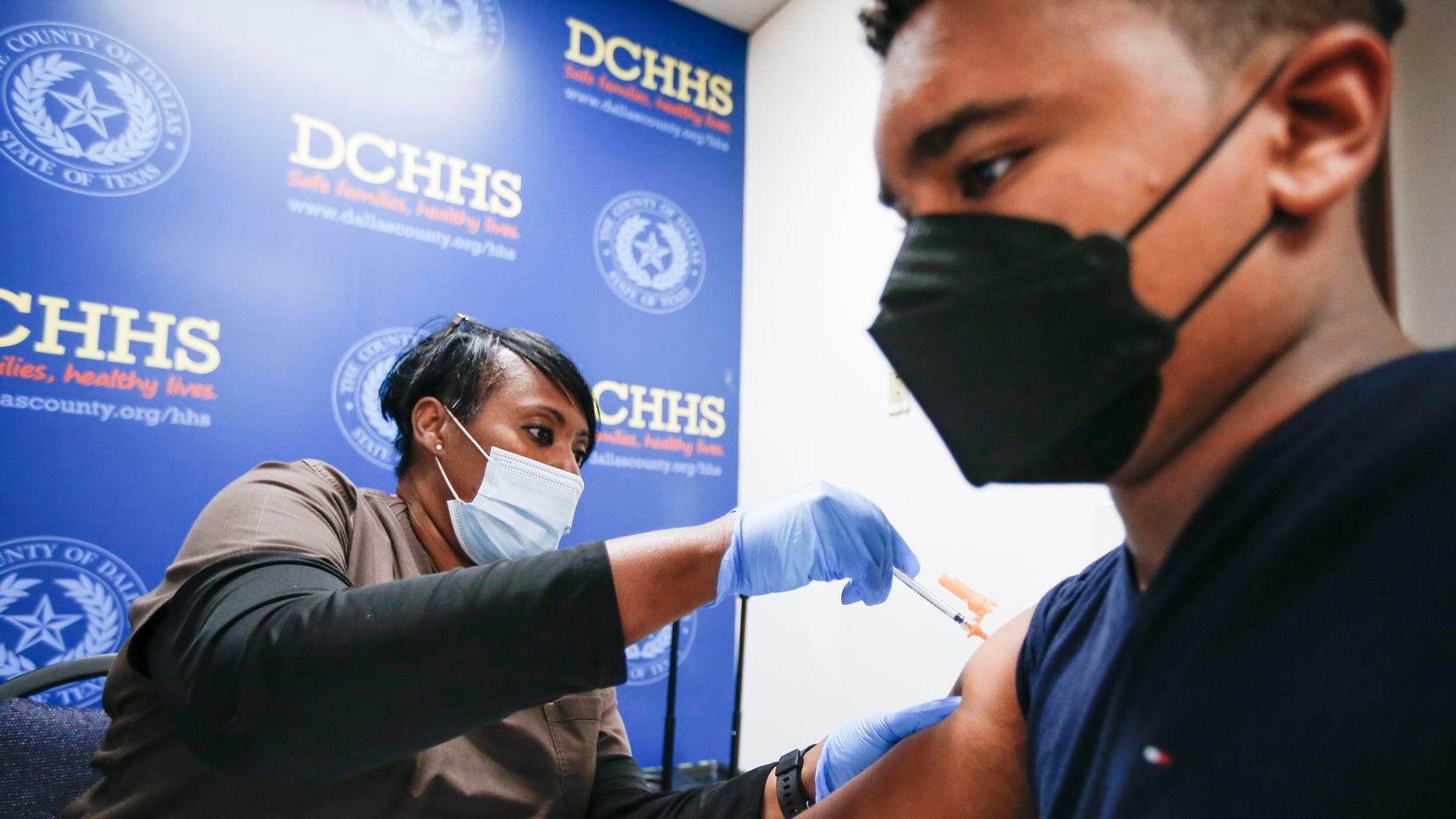 Immunizations Supervisor and registered nurse Barbara Davis administers a Pfizer COVID-19 booster shot to Jonah Taylor, 16, at the Dallas County Health and Human Services building on Dec. 13.