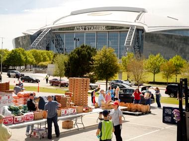 Tarrant Area Food Bank volunteers loaded vehicles with meals for Arlington ISD families outside AT&T Stadium in Arlington in 2020. The food bank will host a mobile market next week in advance of Mother's Day.