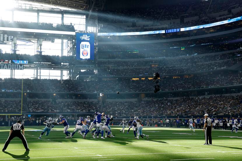 Rayos del sol asoman por un ventanal del AT&T Stadium en el juego de los Cowboys de Dallas...