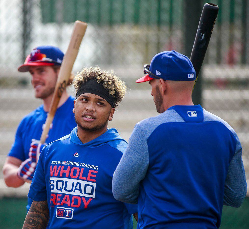 Texas Rangers outfielder Willie Calhoun talks with manager Chris Woodward between rounds of...