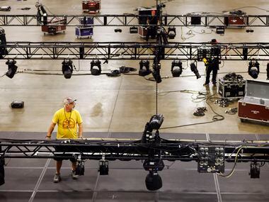 A crew of people set up the light rigging and stage ahead of the 2022 Texas Democratic...