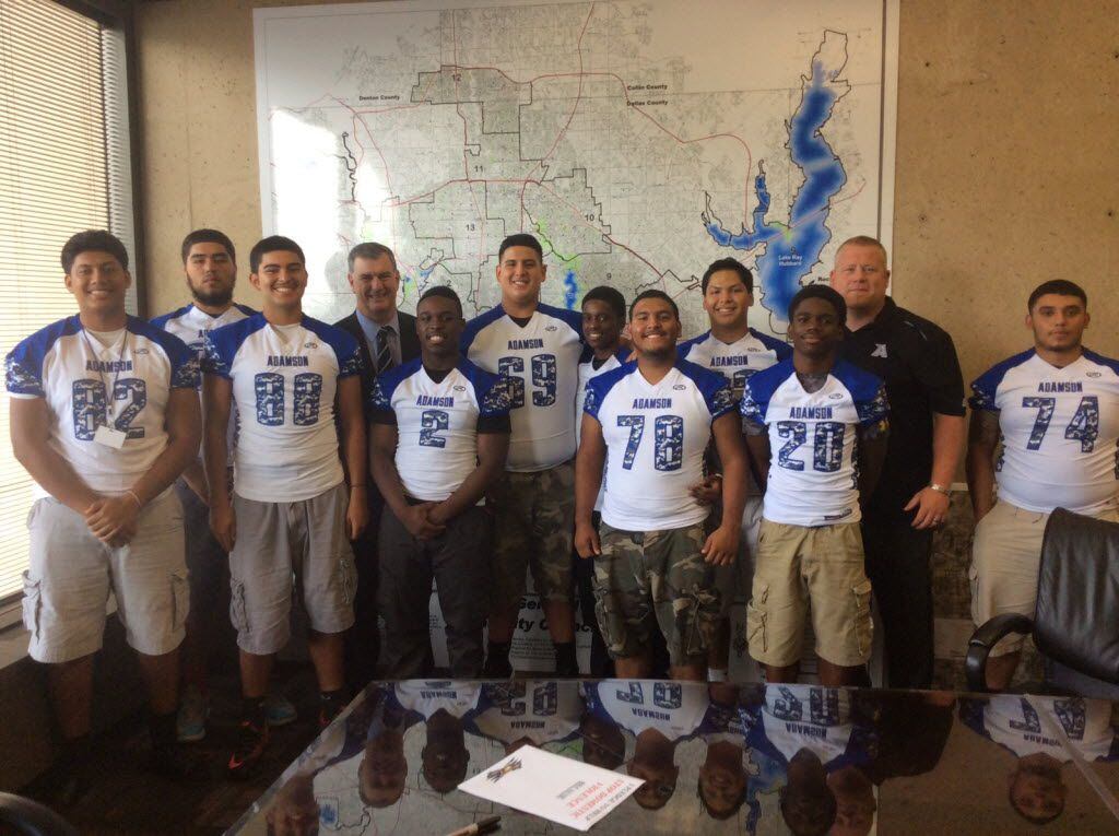 Dallas Mayor Mike Rawlings (left-center) takes a picture with members of the Adamson football team. During at meeting at Dallas City Hall on Sept. 17, 2014, Rawlings signed a pledge, created by Adamson's team, to help take a stand against domestic violence.