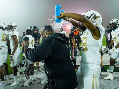 South Oak Cliff’s Izale Williams (28) douses a coach with water bottles following a victory...