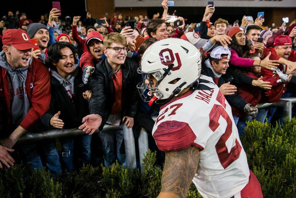 Oklahoma Sooners fullback Jeremiah Hall (27) celebrates with fans after a 34-31 win against...