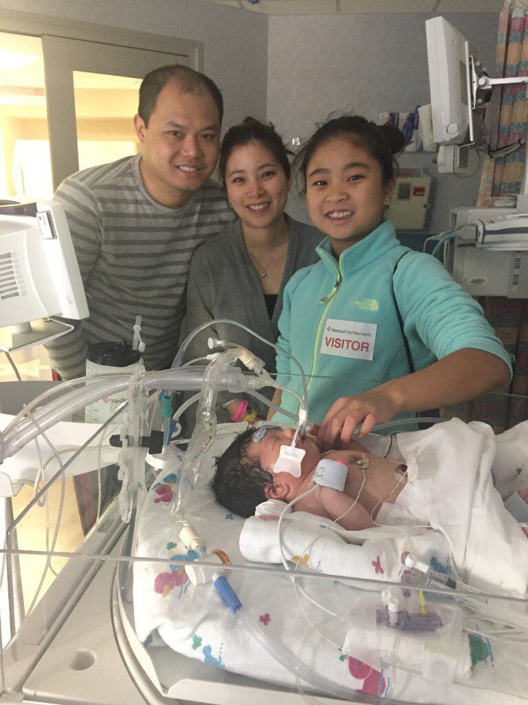 Baby James Reed Ly is surrounded by (from left) his father, Jimmy Ly, mother, Keri Lai, and...