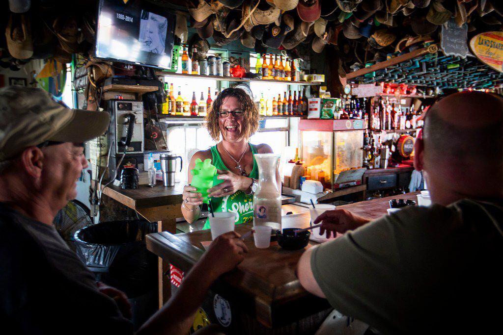 Amy Myers laughs with JP Songer (left) and Brian Underwood as she tends bar at Shorty's...