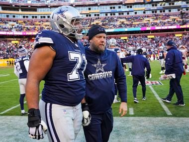 Dallas Cowboys offensive tackle La'el Collins (71) is escorted off the field after being ejected after a scuffle against the Washington Football Team during the second half of an NFL football game on Sunday, Dec. 12, 2021, in Landover, Md..