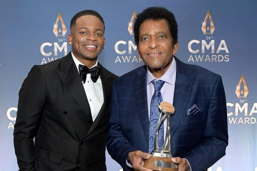Charley Pride (right) holds his lifetime achievement award alongside country singer Jimmie...