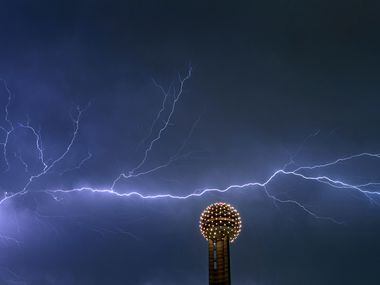 Lightning streaks across the sky behind the Reunion Tower Ball in downtown Dallas Thursday night, Sept. 29, 2011. (AP Photo/Brad Loper - The Dallas Morning News)