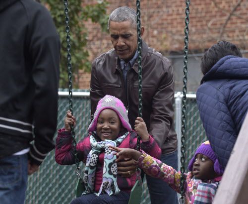 President Barack Obama pushes kids on the swings as they visit "Malia and Sasha's Castle,"...