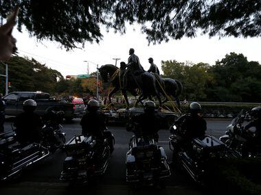 Motorcycle officers wait to escort a truck carrying the Robert E. Lee statue at Robert E....