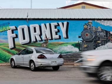 Traffic passes by a mural in downtown Forney.