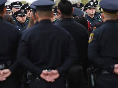 Police officers stand at attention around the casket of Grand Prairie police officer Brandon...