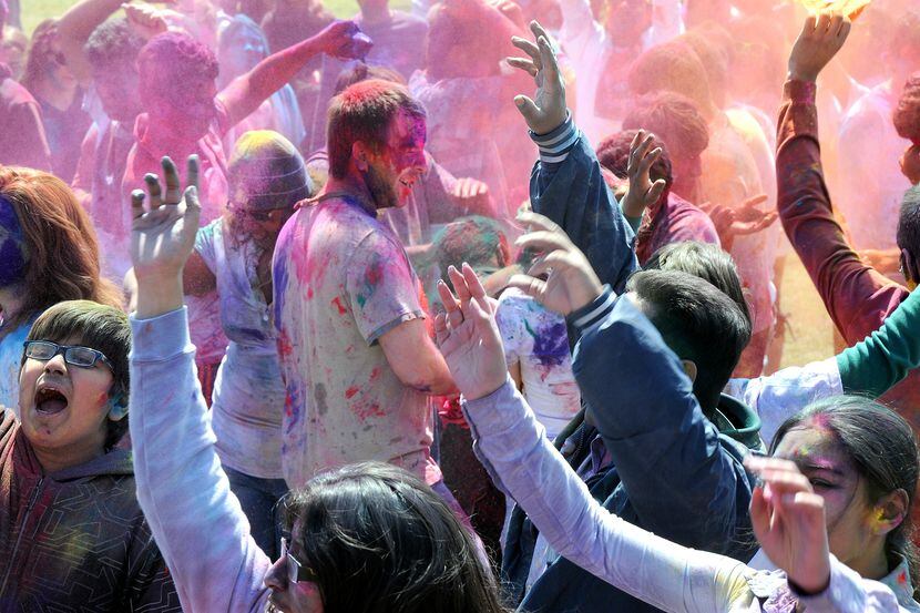 Revelers celebrate Holi with colored powder.