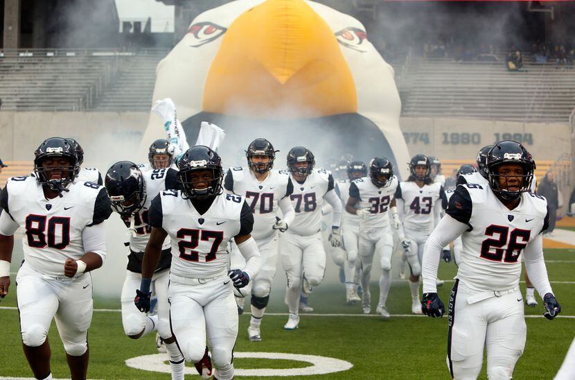 Allen Eagles players bolt onto the field from the team inflatable for the second half of...