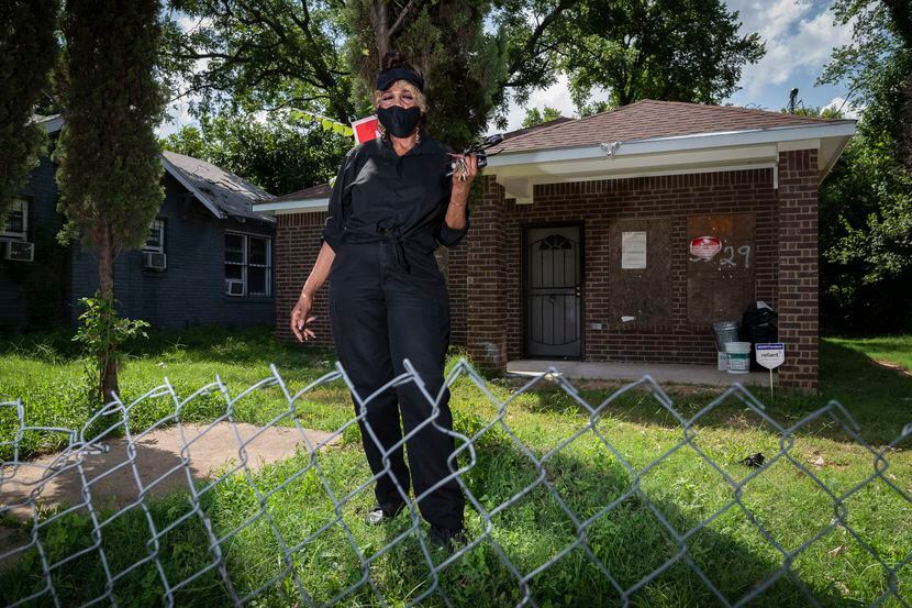 Doretha Traylor, 71, wearing a face mask, outside her soon to be home that is being repaired...