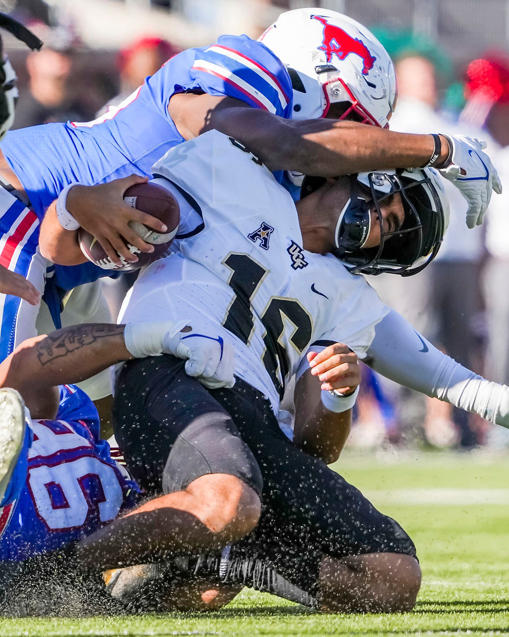 UCF quarterback Mikey Keene (16) is sacked by SMU defensive tackle DeVere Levelston (bottom)...