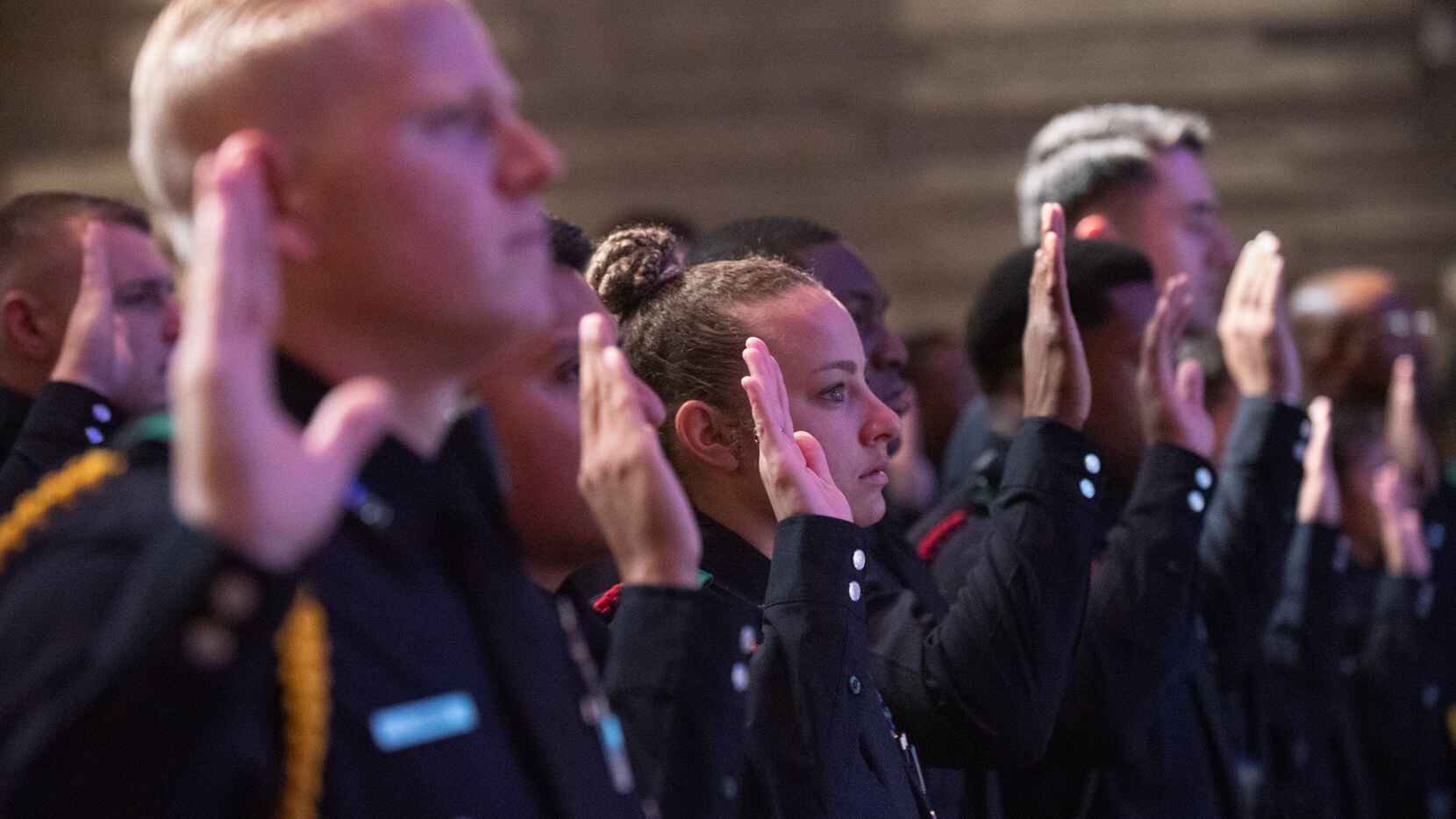Police Officer Chelsea Boykin, center, raises her right hand with other officers for the...