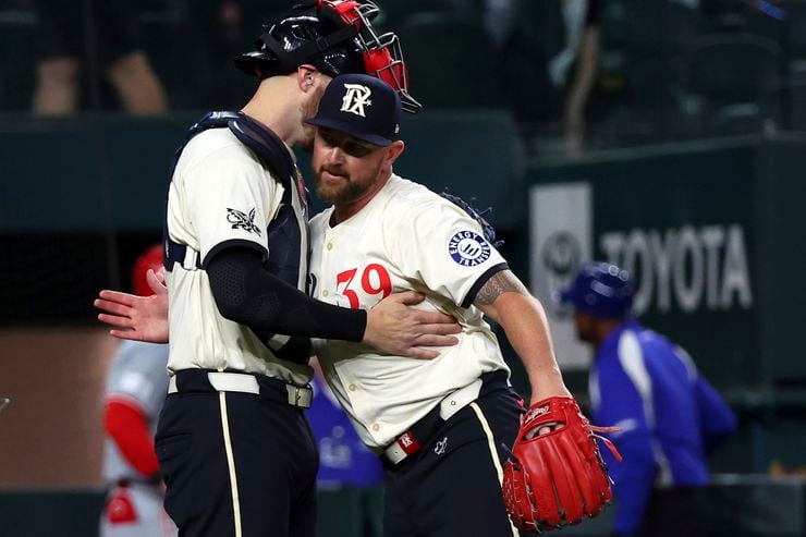 Texas Rangers catcher Jonah Heim, left, hugs pitcher Kirby Yates after the team's win over...