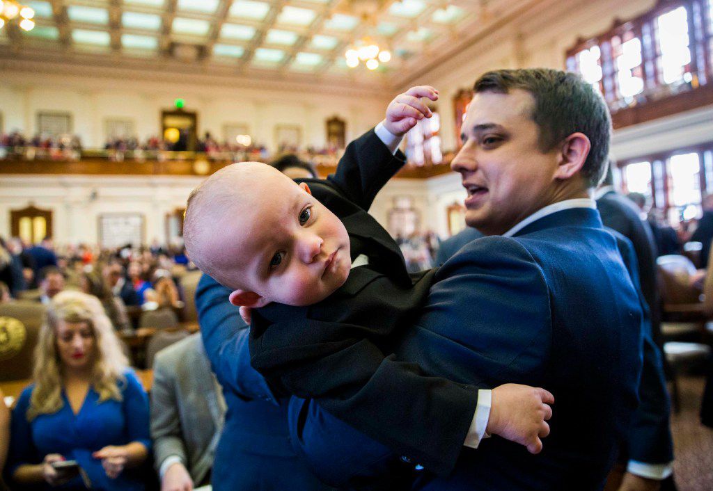 Texas State Representative Brisco Cain wrangles his son, Crockett Cain, 13 months, during...
