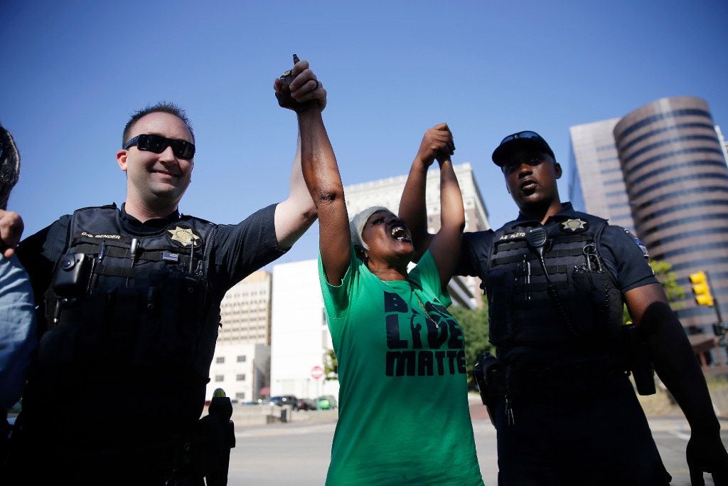 Angie Pitts of Tulsa holds hands with police officers while protesting the death of Terence...