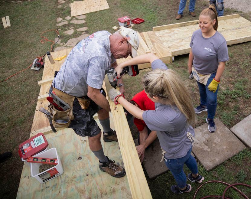 (From left) Don Emmerich with the Texas Ramp Project holds a wood plank as Grayson Nastri...