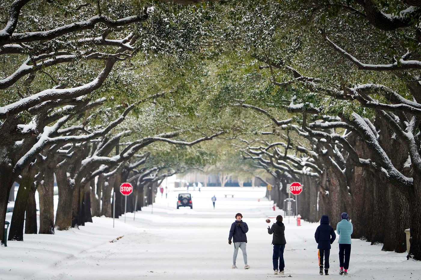 People toss a football on Bishop Boulevard on the SMU campus after a second winter storm...