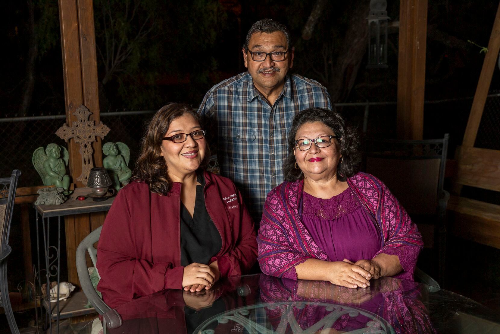 Erica Solis (left) sits with her parents, Debbie Solis and Daniel Solis, outside the family...