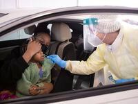 Tamera Stephens holds daughter Victoria Stephens, 2, from Waxahachie as Krystal Stroub with Nomi Health administers her COVID-19 test at the Ellis Davis Field House parking lot on Thursday, Jan. 6, 2022, in Dallas, TX. 