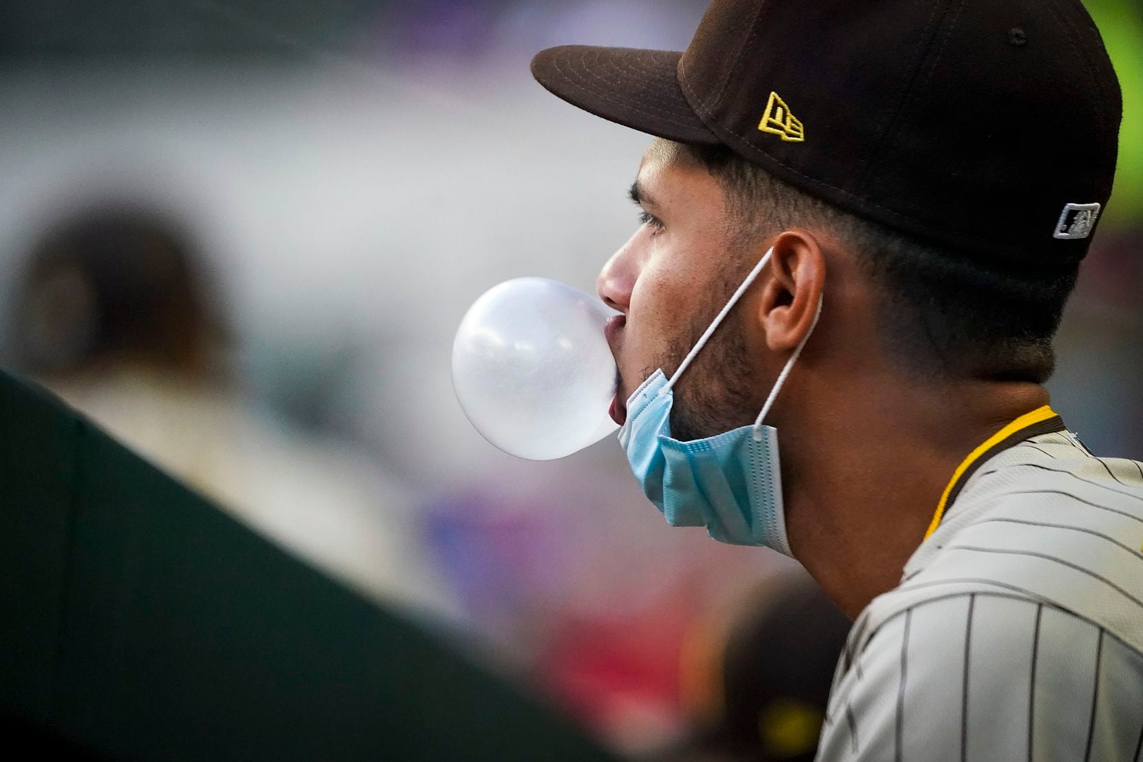 San Diego Padres second baseman Tucupita Marcano didn’t let his face mask stop him from perfecting his bubble gum game in the Globe Life Field dugout in April.