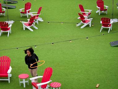 Patrons play with a hula hoop on the patio at Chicken N Pickle on Friday, Dec. 9, 2022, in...