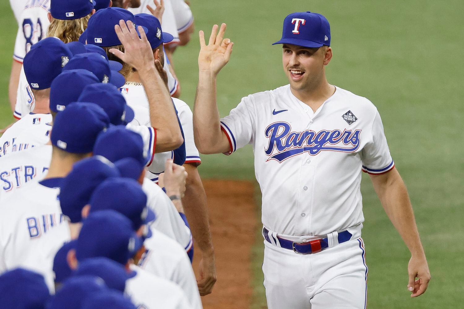 Texas Rangers first baseman Nathaniel Lowe high-fives his teammates after being introduced...