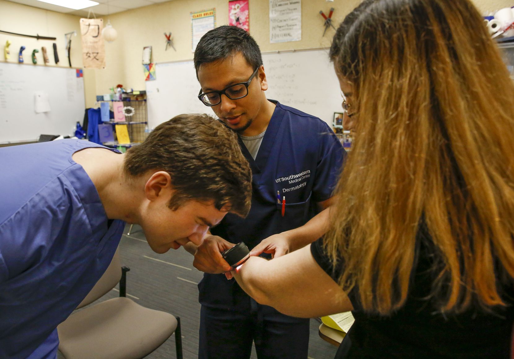 Second year medical student Hector Filizola, left and Dermatologist Paras Vakharia MD both from UT Southwestern Medical Center check moles on the skin of Norma Taboada's arm during a free health fair coordinated by the Mexican consulate at Mountain View College in Dallas, on Saturday October 21, 2019.