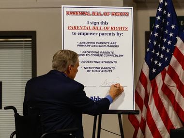 Governor Greg Abbott signs a card referring to his declaration of parental rights to...