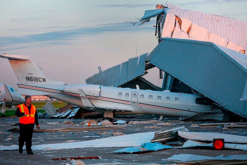 Una persona evalúa los daños causados por fuertes vientos en un hangar del Aeropuerto...